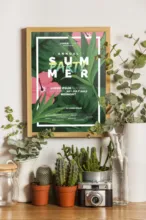 A framed poster with tropical plants on a table template. - PSD Mockup