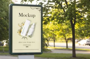 A billboard mockup in a park with trees in the background. - PSD Mockup