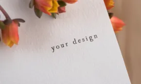 A **mockup** card with flowers on it that says your design. - PSD Mockup