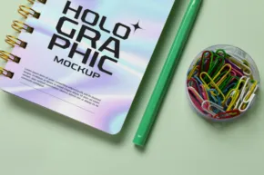 Holographic notebook mockup on a green surface. - PSD Mockup