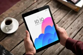 A person is holding an ipad with an image of a cloud on it, creating a mockup for a cloud-based app. - PSD Mockup