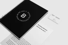 A black notebook and business card template on a white surface. - PSD Mockup